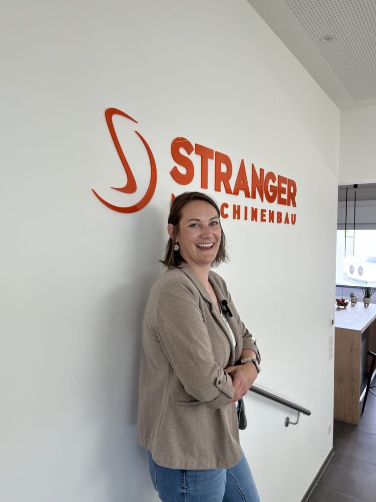 Janine Kratochwil vor dem Stranger-Maschinenbau-Logo