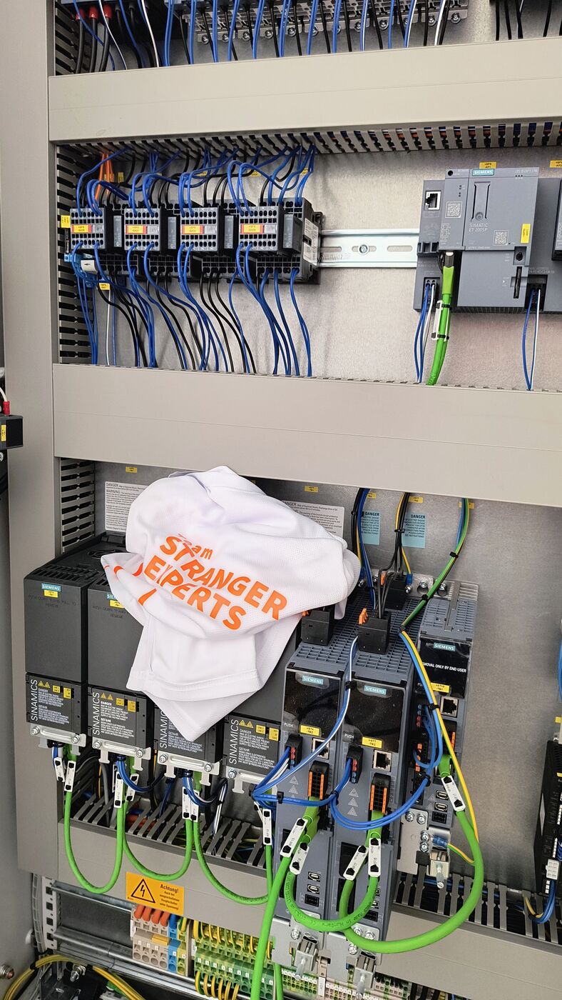 Laufshirt im geöffneten Schaltschrank der Steuerungstechnik