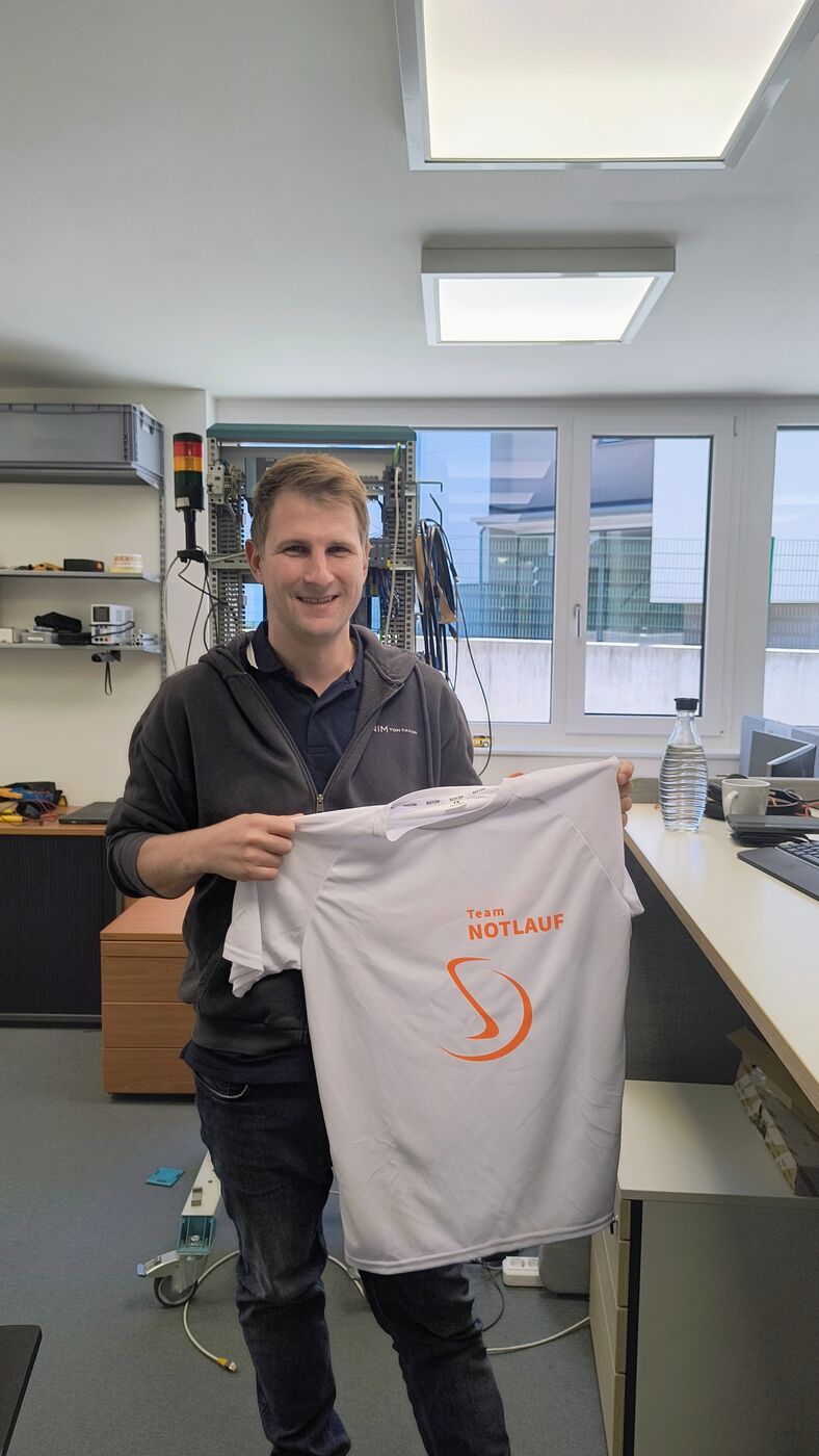Mitarbeiter der Steuerungstechnik mit seinem Laufshirt für den Businesslauf 2026