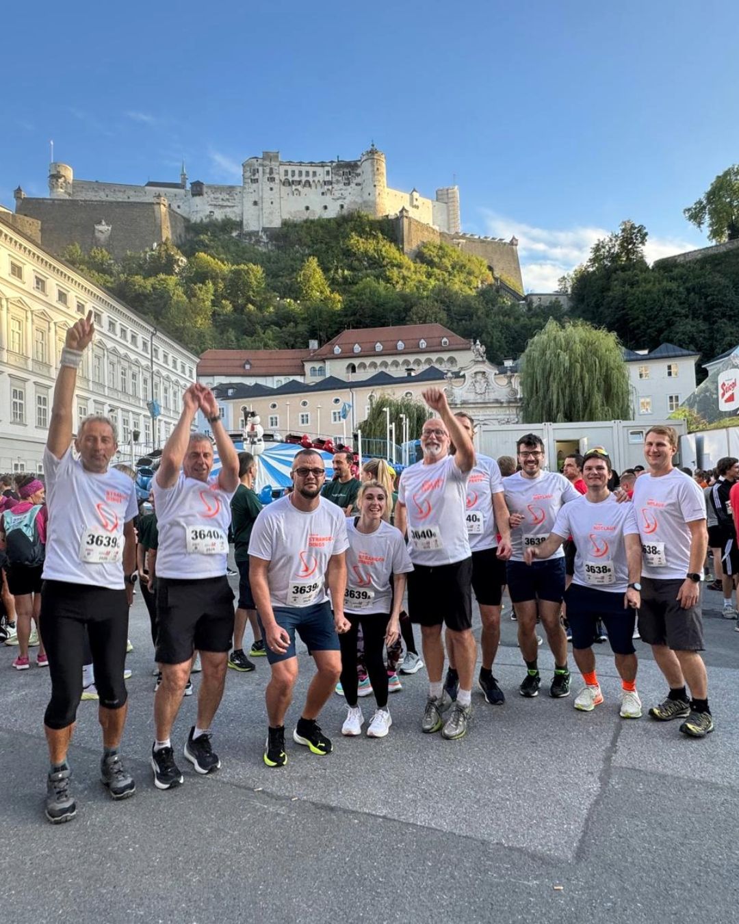 Die Teams von Stranger Maschinenbau vor dem Start des Salzburger Businesslauf 2026 mit der Festung Hohensalzburg im Hintergrund