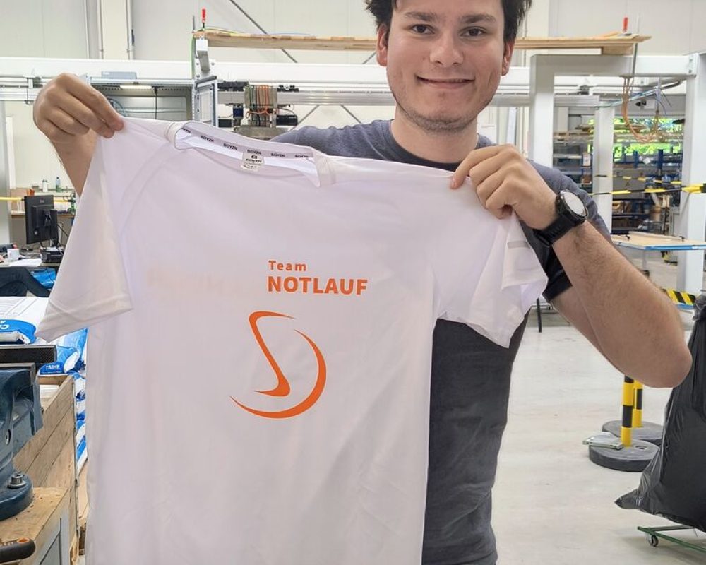Stranger-Mitarbeiter in der Montagehalle mit dem Laufshirt von Team NOTLAUF
